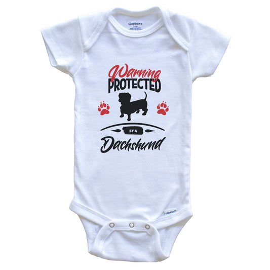 Warning Protected By A Dachshund Funny Dog Owner Baby Bodysuit